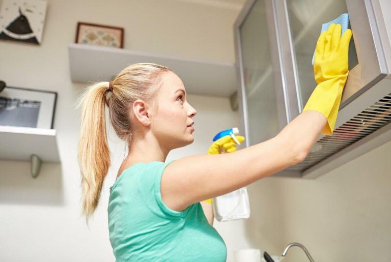 a young lady cleaning a microwave